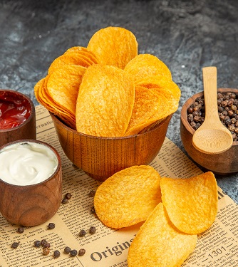 vertical-view-delicious-homemade-chips-pepper-bowl-mayonnaise-ketchup-sauce-with-spoon-newspaper-gray-background