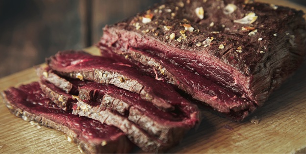 Closeup focus grilled meat thin sliced on wooden board